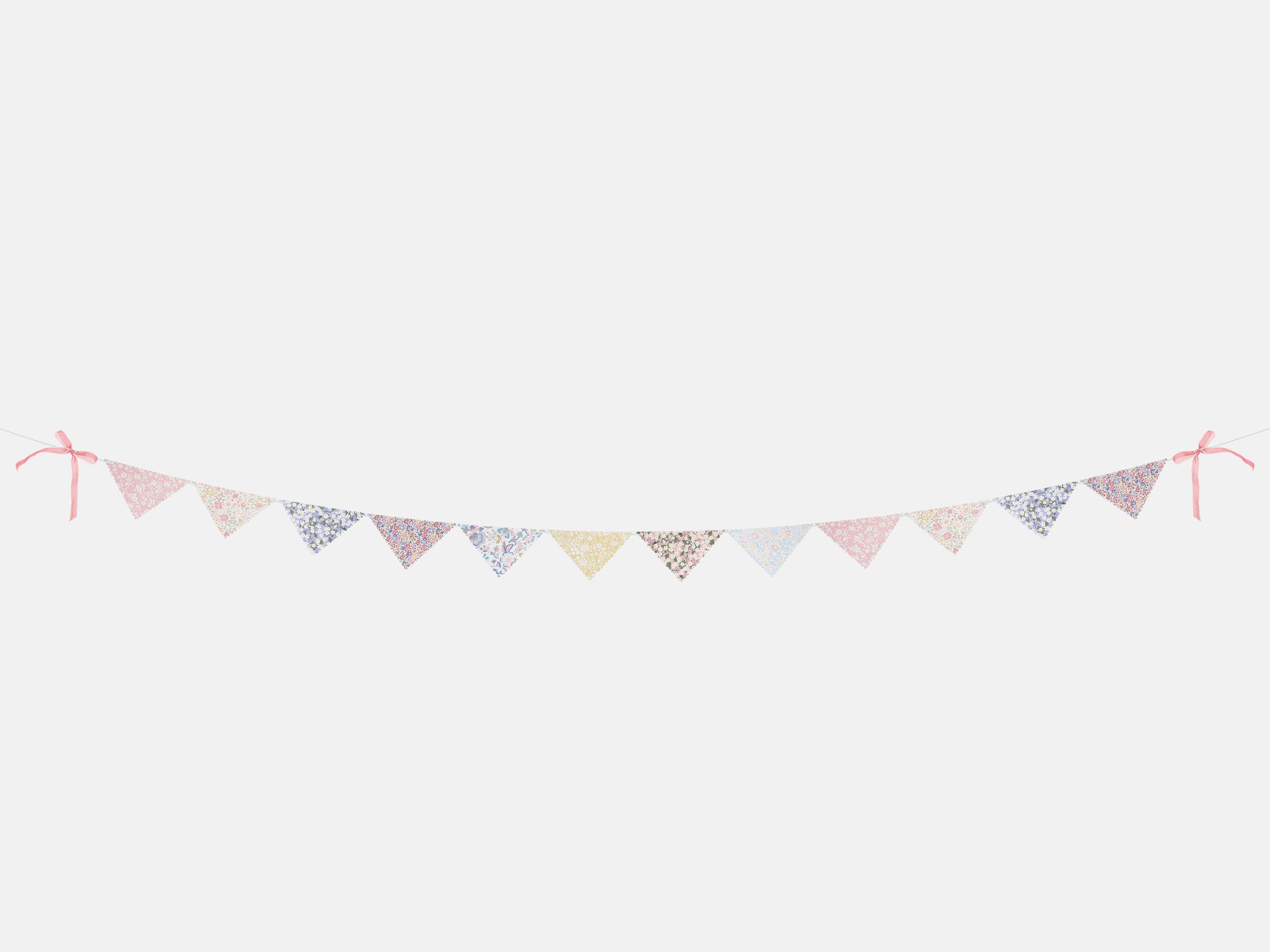 Floral patterned bunting with pink ribbons on a white background | Meri Meri x Liberty Scallop Edge Garland