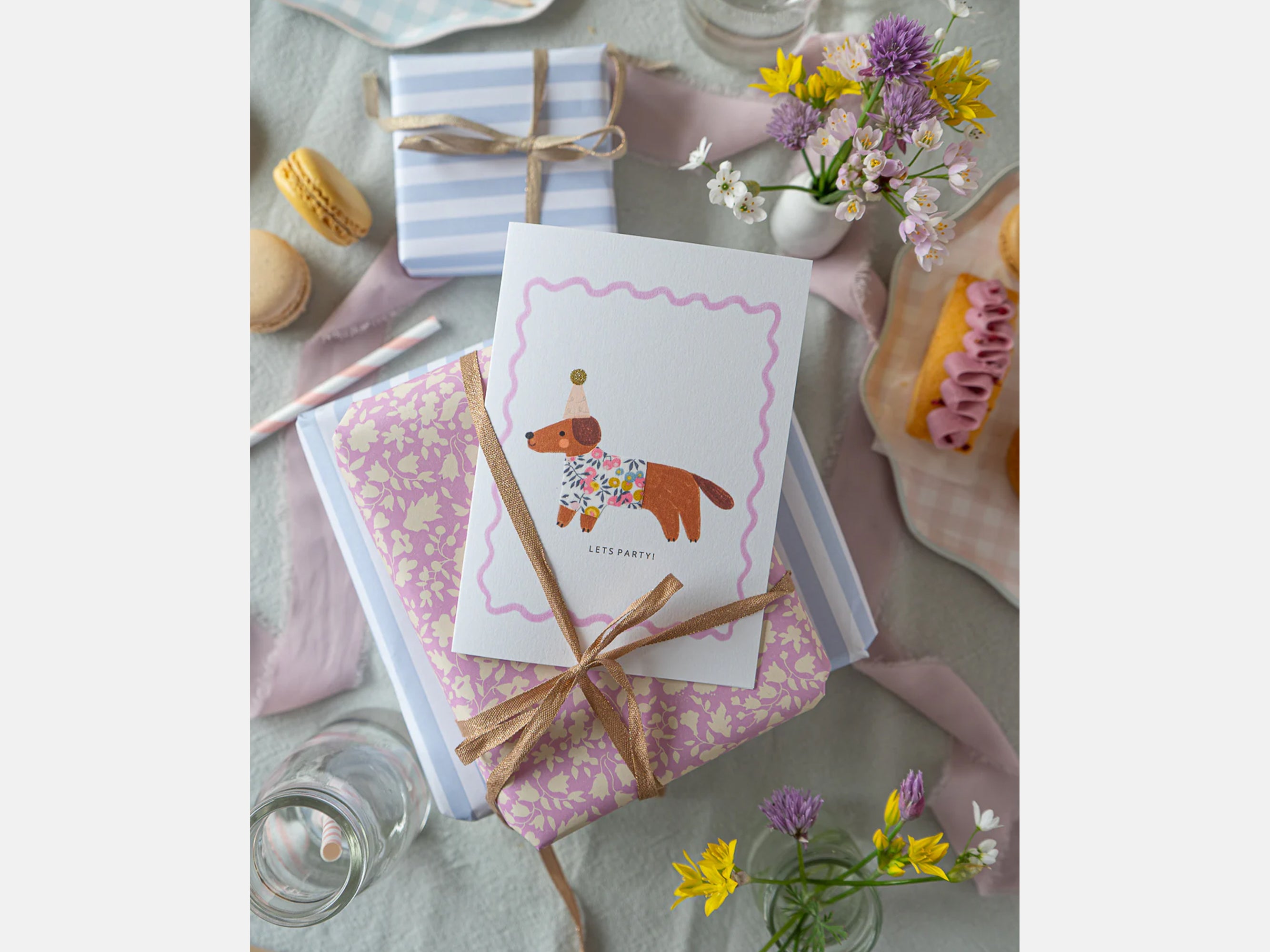 Liberty greeting card on a decorative table setting with flowers and macarons | Sausage Dog Birthday Card - Liberty Wiltshire Bud Print | Holme & Moss