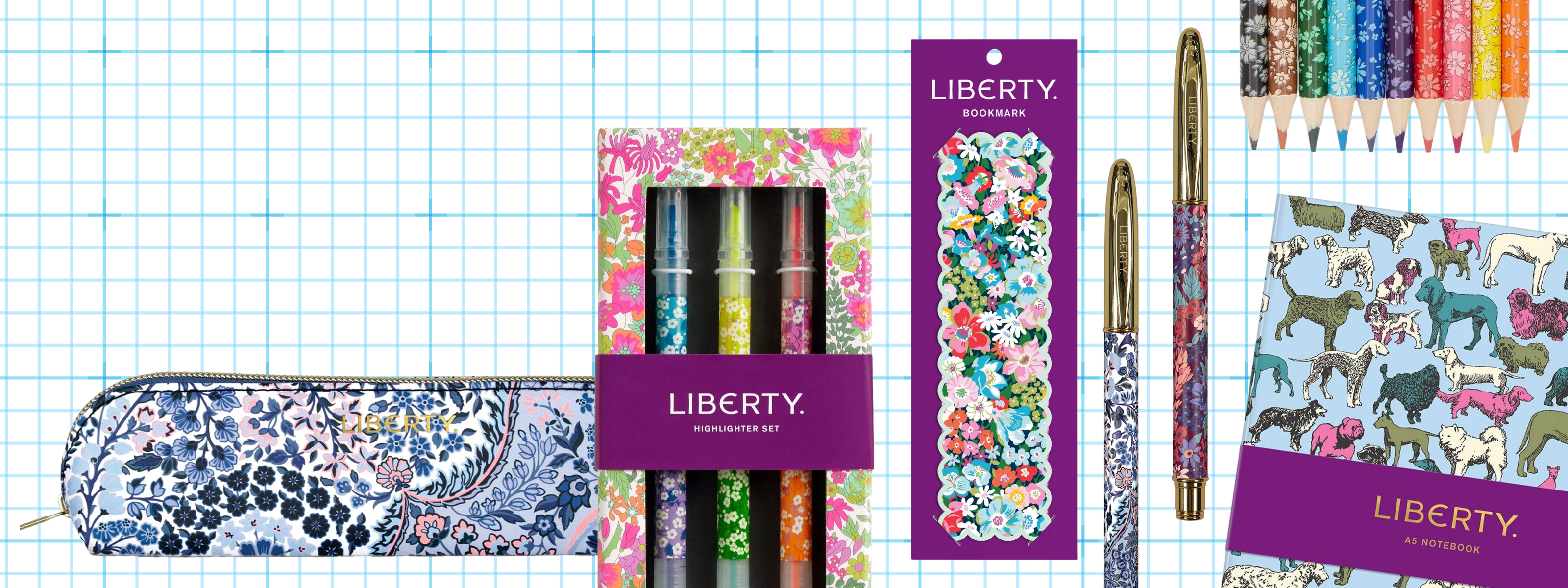 Collection of Liberty branded stationery items including a pencil case, pens, and pencils on a grid background. | Liberty Stationery | Holme & Moss