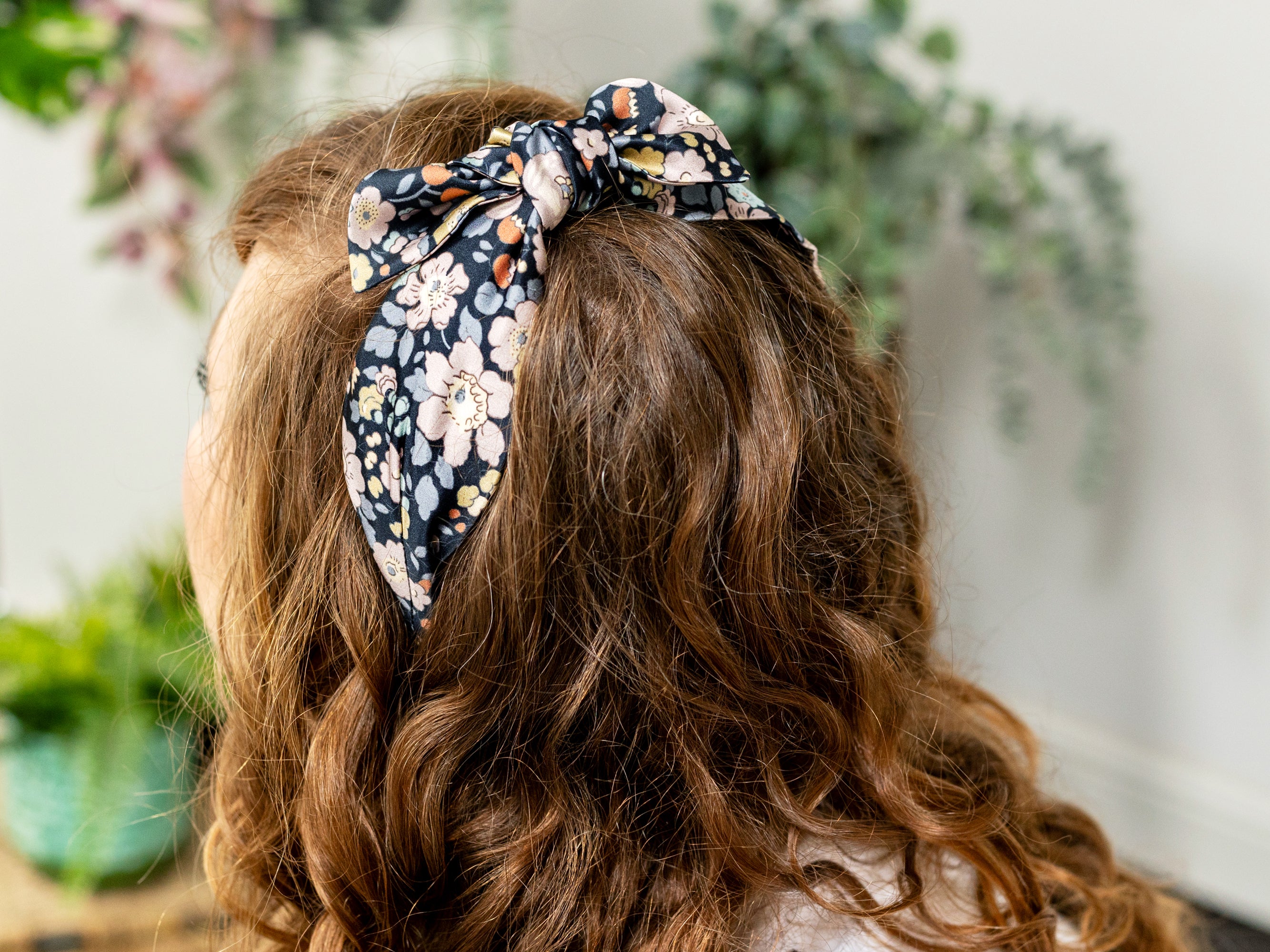 Model Wearing a Side Bow Headband, Liberty London Silk Satin Betsy Field Print | Holme & Moss