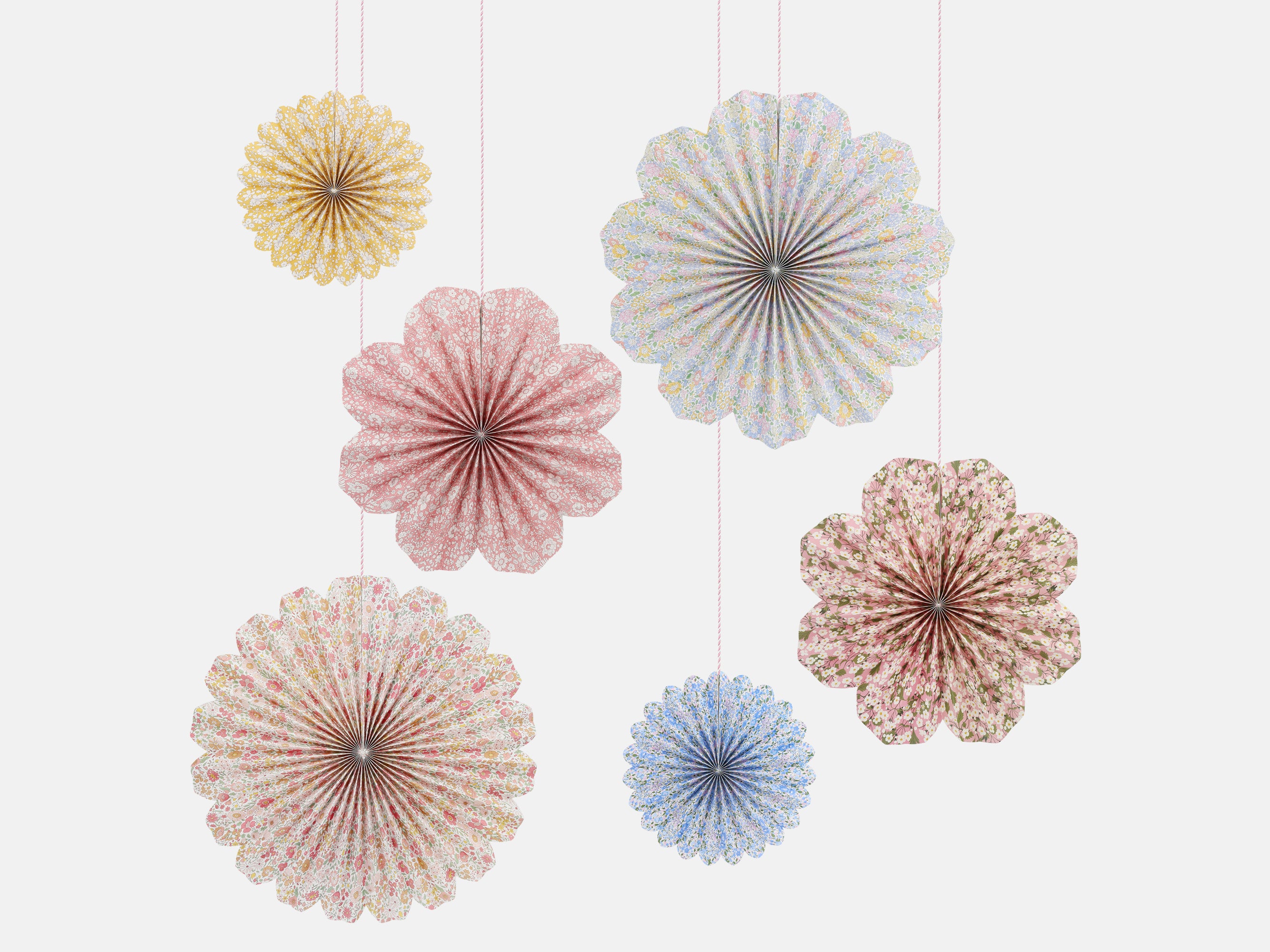Decorative Liberty print paper fans in pastel colours hanging against a white background | Meri Meri x Liberty Paper Pinwheel Decorations (6) | Holme & Moss