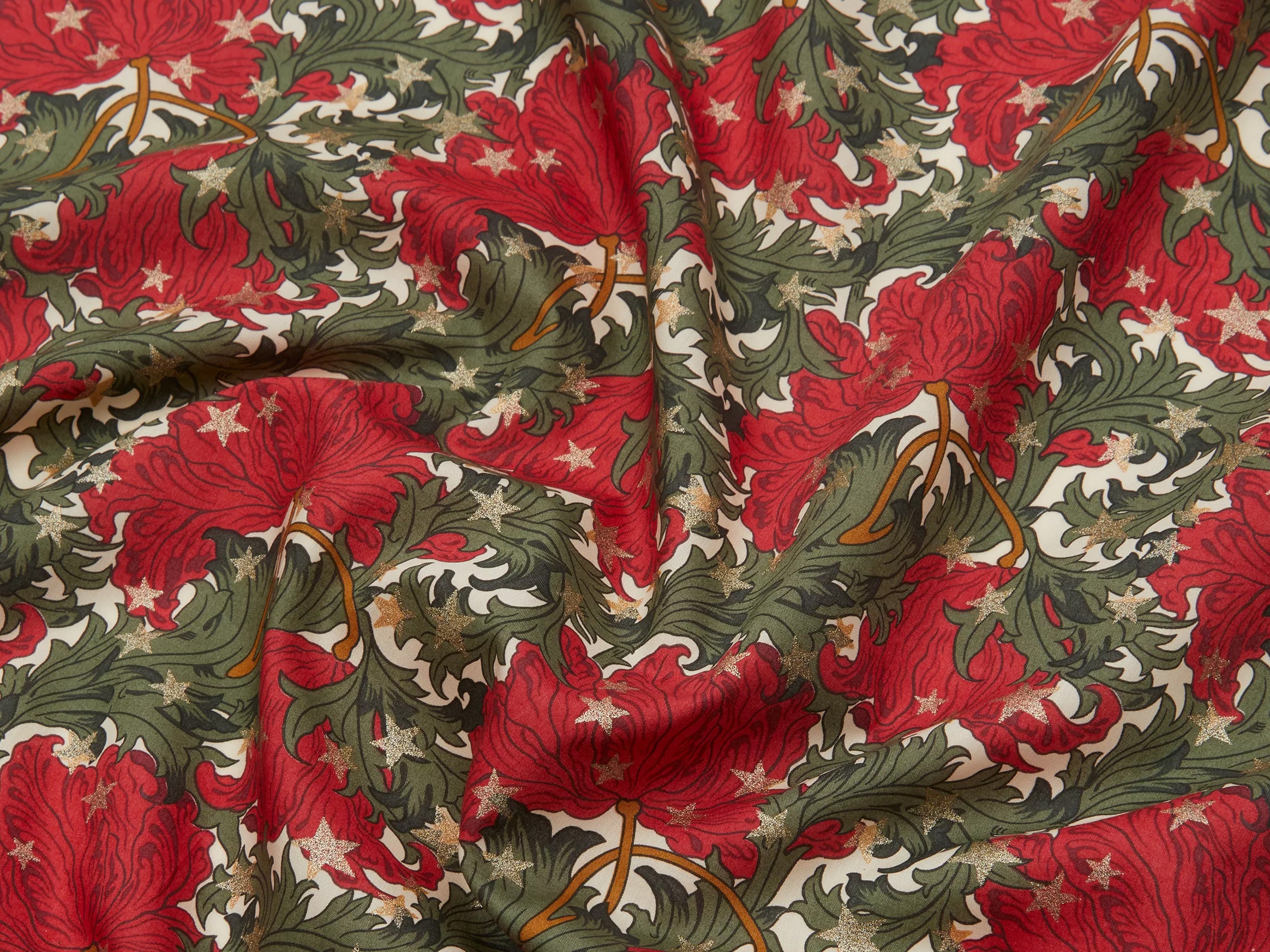 Liberty fabric in rich red and green, scattered with shimmering gold stars | Holme & Moss
